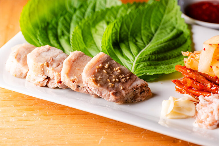 Steamed pork served with perilla leaves